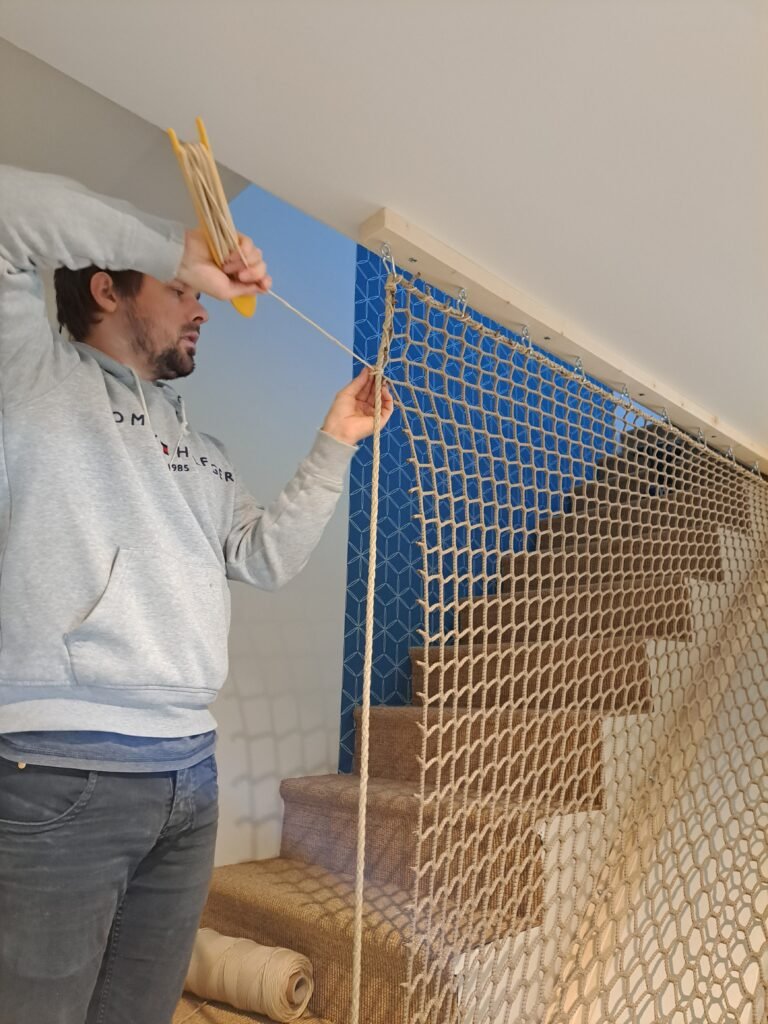 Morgan installe un garde-corps en filet amovible sur un escalier pour sécuriser une maison