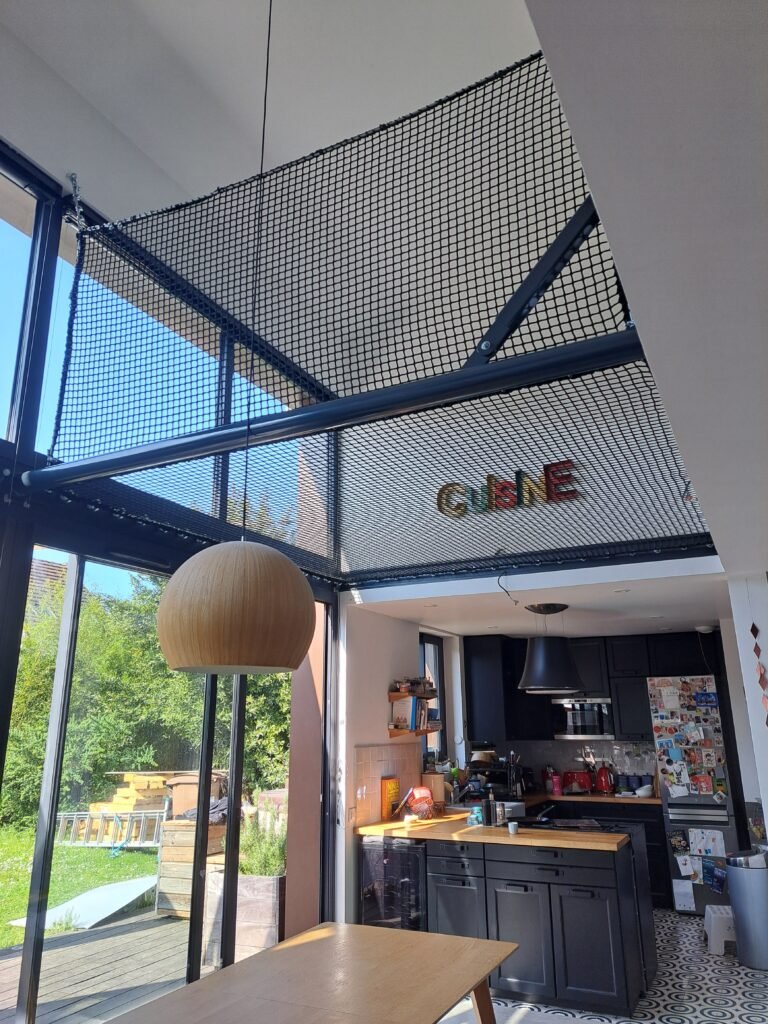 Installation d’un filet de mezzanine avec garde-corps au-dessus d’un espace de vie et d’une cuisine, sans bloquer la lumière naturelle