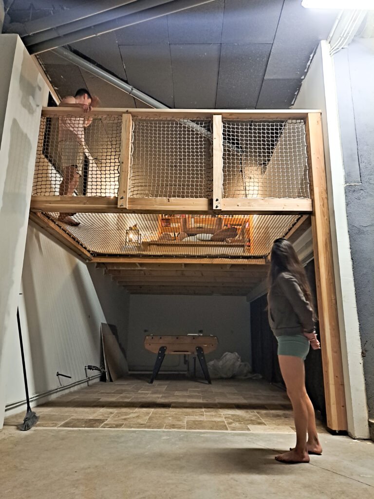 Installation d’un filet de mezzanine avec garde-corps sur structure en bois dans un garage transformé en espace détente et jeux