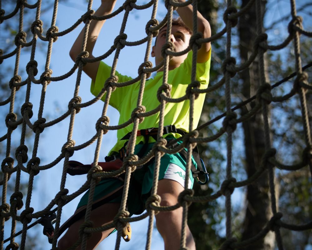 Garçon faisant de l’accrobranche sur un agrès Tarzan dans un parc Arboricorde
