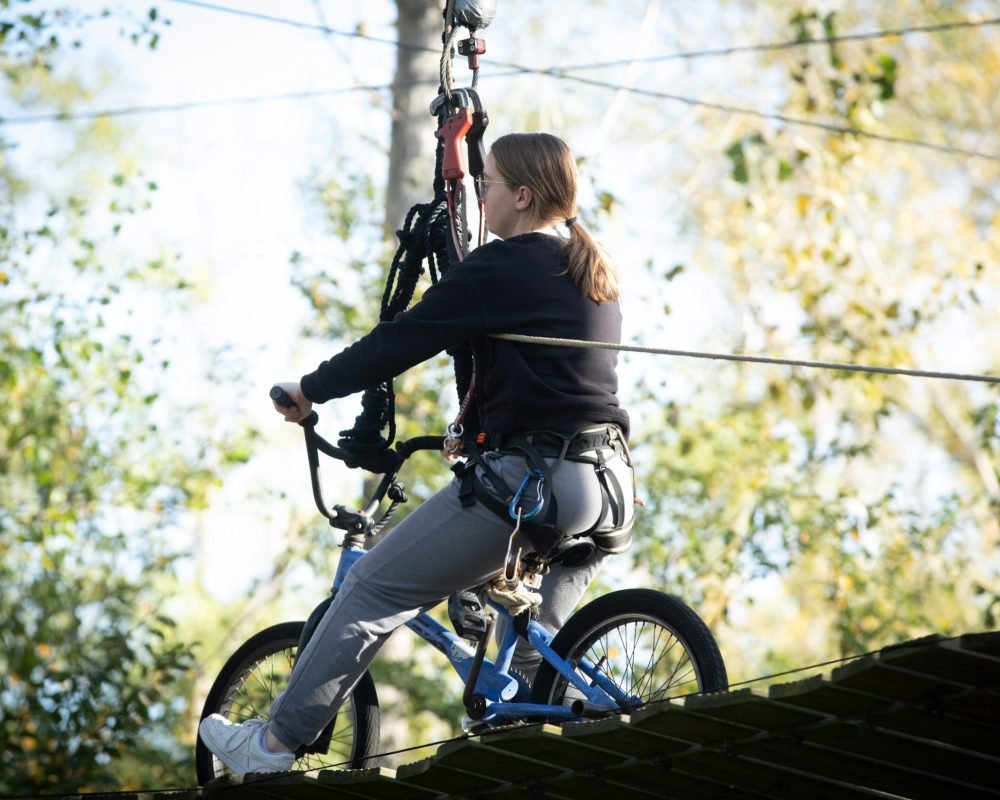 jeune fille faisant de l’accrobranche sur un agrès vélo à Pangaea